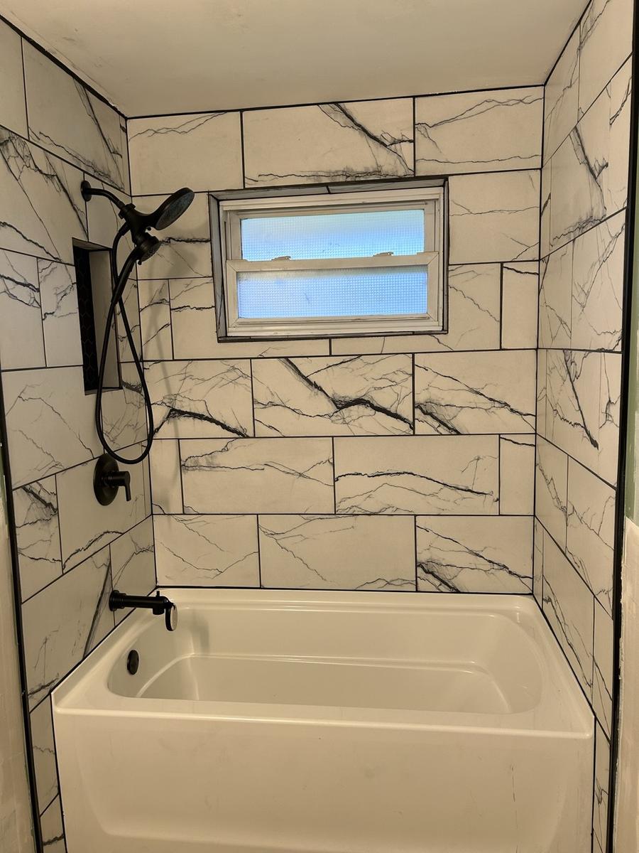 Bathroom remodel with new large marble-look wall tile and a new tub