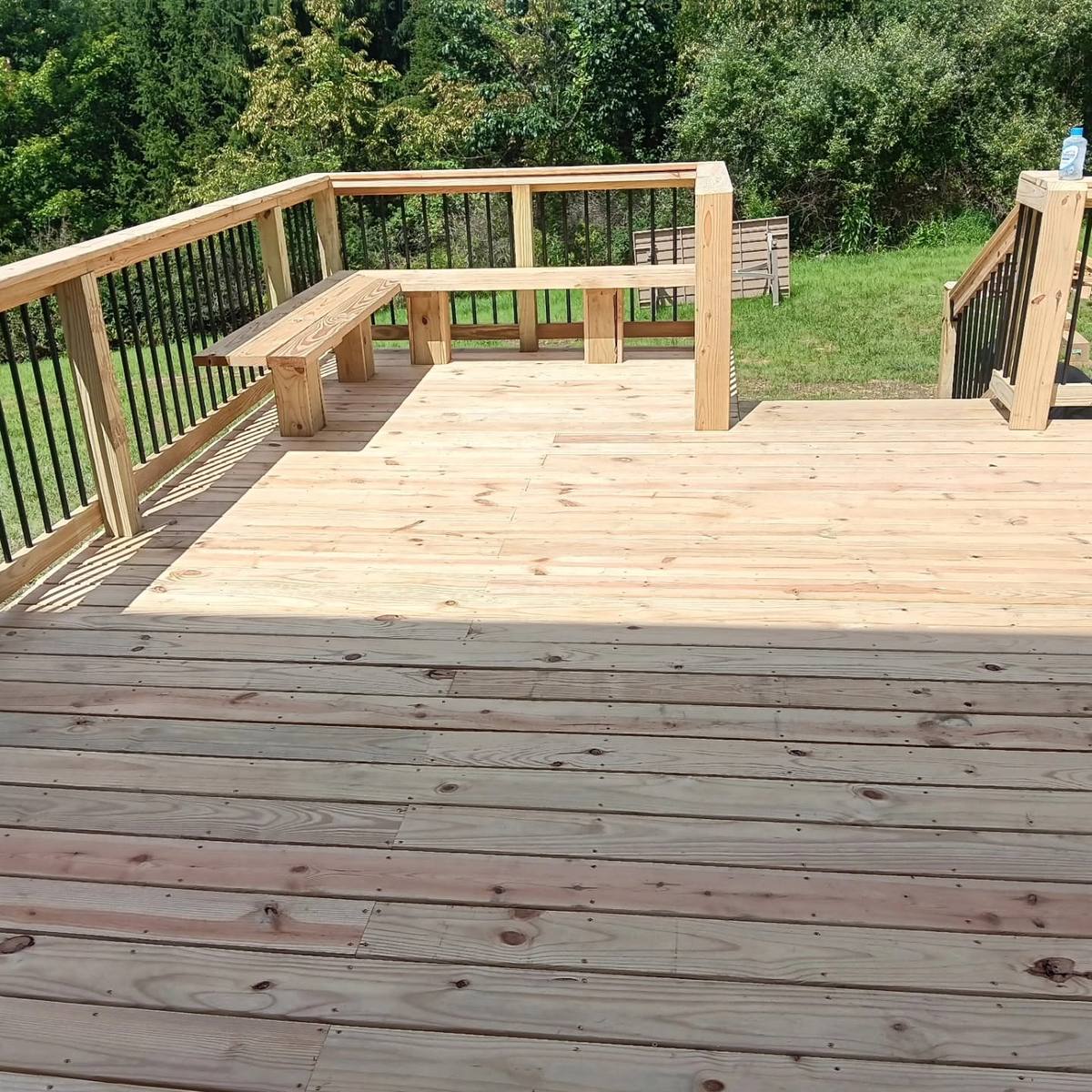 Wood deck with a built-in bench and black metal balusters