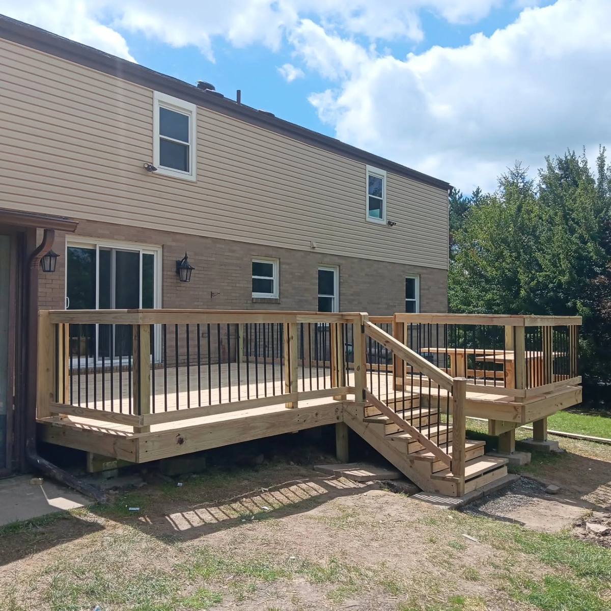 Raised wood deck with a full set of stairs down to the yard