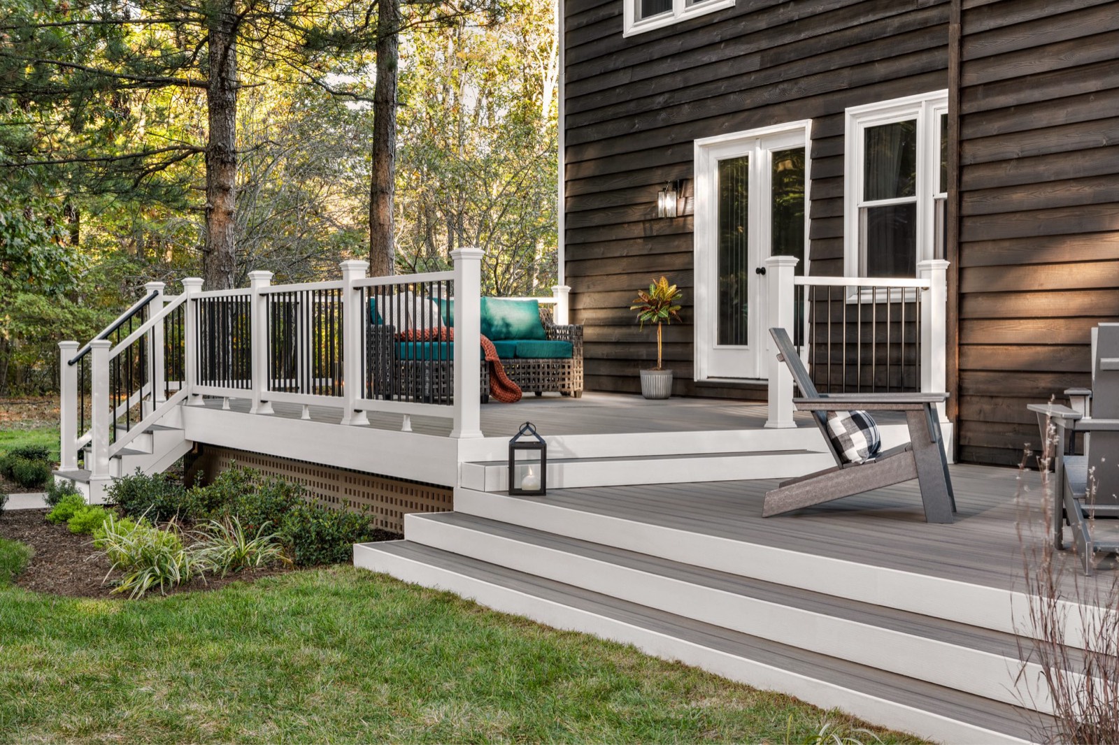 Gray Trex composite deck with wide steps and white railing on the back of a home