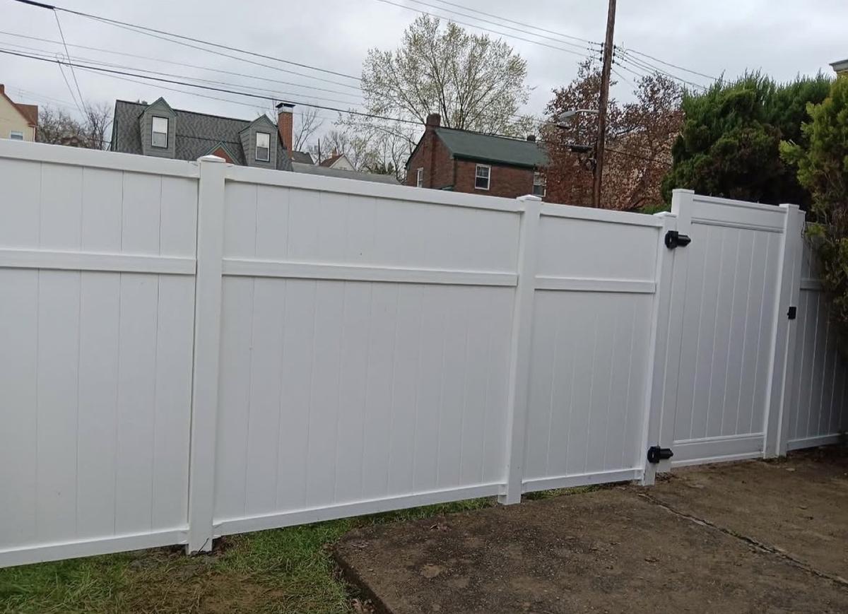 New white vinyl privacy fence with a matching walk-through gate