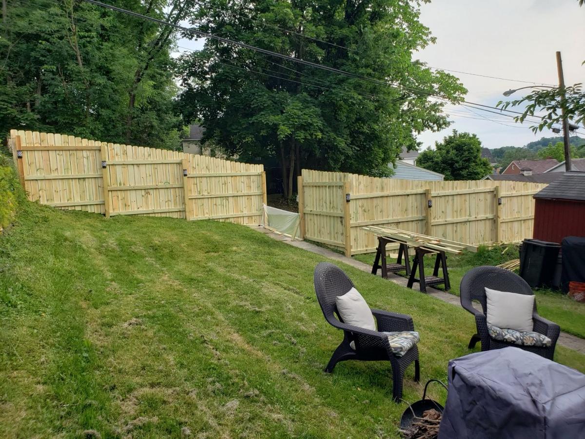 New wood privacy fence stepping along a sloped backyard