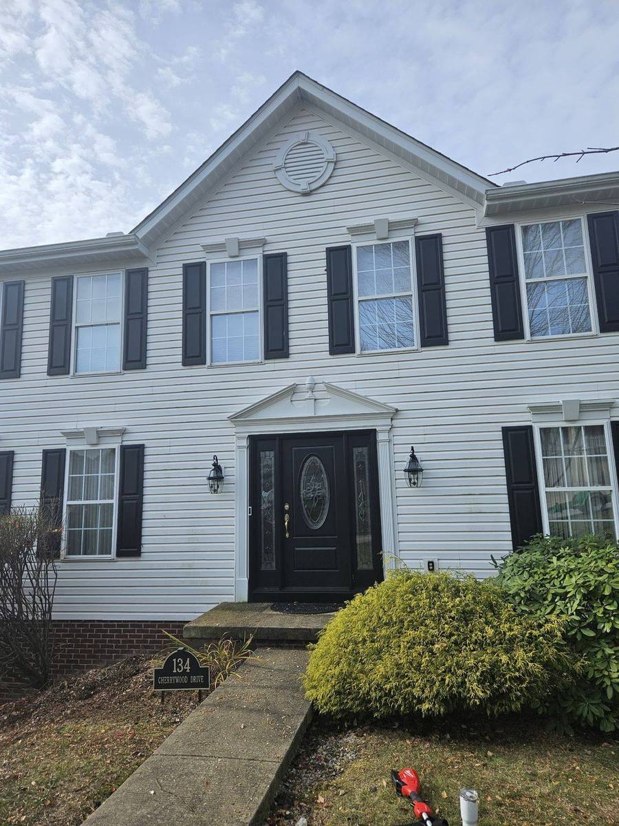 Front of a white two-story colonial home with black shutters